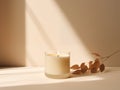 Minimalist burning wax candle in clear glass on natural beige stone background with copy space, styled commercial