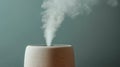 Minimalist ceramic humidifier emitting steam against a teal background Royalty Free Stock Photo