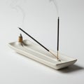 A minimalist ceramic incense holder with two burning incense sticks and a cone, Royalty Free Stock Photo