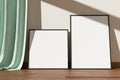 Minimalist and clean black poster or photo frame mockup on the wooden floor leaning against the room wall. 3D Rendering Royalty Free Stock Photo