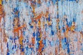 Minimalist colourful textured background of old and rusted white, blue, brown and orange paint on metallic surface, in direct sun