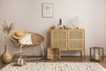 Minimalist composition of cozy and domestic space of living room with rattan commode, mock up poster frame, decoration, vase, Royalty Free Stock Photo