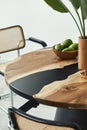 Minimalist composition on the design wooden table with fruits, tropical leaf in vase, abstract paintings and stylish chair. Modern