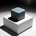 Minimalist composition featuring a closed ring box on a white pedestal, bathed in dramatic chiaroscuro lighting Royalty Free Stock Photo