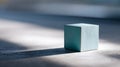 Minimalist composition featuring a single light blue wooden cube casting a long shadow on a textured surface with soft natural Royalty Free Stock Photo