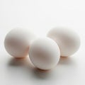 Three soft white textured spheres sit on a smooth surface with subtle lighting effects Royalty Free Stock Photo