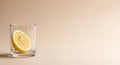Minimalist composition with lemon slice in glass on subtle beige background Royalty Free Stock Photo