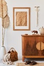 Minimalist composition of living room with brown mock up picture frame, carpet, macrame, dried tropical leaf, decoration. Royalty Free Stock Photo