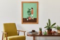 Minimalist composition of living room with brown mock up picture frame, plant, retro armchair, dried tropical leaf, decoration. Royalty Free Stock Photo