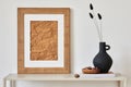 Minimalist composition of living room interior with mock up poster frame, beige commode, vase and personal accessories. Royalty Free Stock Photo