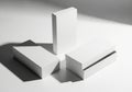 Minimalist composition of white rectangular prisms casting dramatic shadows on a bright surface Royalty Free Stock Photo