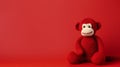 Minimalist Crocheted Stuffed Monkey On Vibrant Red Background