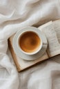 A minimalist depiction of an open book and a cup of coffee on a white background