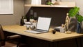 Minimalist desk workspace with laptop mockup and decor on wood table against the grey wall Royalty Free Stock Photo