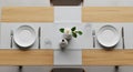 Minimalist dining table setup features two place settings on a light wood surface with a gray Royalty Free Stock Photo
