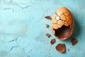 Minimalist Easter idea represented by a chocolate egg with a cracked and broken eggshell, offering a clean and simple Royalty Free Stock Photo