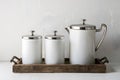 Minimalist elegance with sleek white cylinders and silver lids on rustic tray