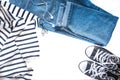 Minimalist and fashionable outfit - blue jeans, black sneakers, striped pullover and headphones isolated on white Royalty Free Stock Photo