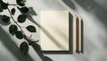 Minimalist flat lay of a blank notebook and pencils bathed in dappled sunlight and leaf shadows Royalty Free Stock Photo