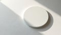 Minimalist flat lay features white round platform with textured backdrop. Soft light creates shadows, adding depth, style. Image Royalty Free Stock Photo