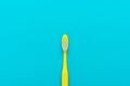 Minimalist flat lay photo of yellow toothbrush over turquoise blue background