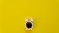 Minimalist flat lay of white alarm clock shape of coffee cup on yellow background