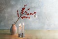 Minimalist fourth advent with four small burning candles and a berry branch with a white christmas ball in a vase, snowy Royalty Free Stock Photo