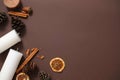 Minimalist frame of Christmas concept. Top view of dried decorations with white candles on a dark brown background