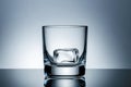 Minimalist glass with ice cube on reflective surface Royalty Free Stock Photo