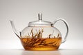 a minimalist, glass teapot with loose tea leaves inside on a white surface