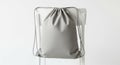 Minimalist grey drawstring backpack on a clear acrylic chair Royalty Free Stock Photo