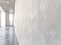 A minimalist hallway features a continuous microcement floor and wall, creating a seamless and spacious feel