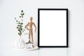 Minimalist home decor with empty frame mock-up on white wall background Royalty Free Stock Photo