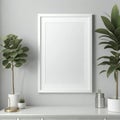 Minimalist home interior with blank white picture frame, plants, and decorative items on a sleek cabinet against a gray wall Royalty Free Stock Photo