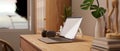 Minimalist home office with laptop mockup, headphones and accessories on wood table