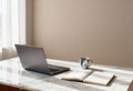 A minimalist home office workspace with a laptop and notebook on a marble desk. Modern remote work setup with natural light and Royalty Free Stock Photo