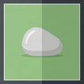 A smooth, white stone with a shiny surface, set against a green Royalty Free Stock Photo