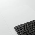 A minimalist image showing the corner of a black keyboard on a white surface. The Royalty Free Stock Photo