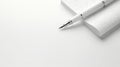 A minimalist image of a white pen on a white notepad. The pen has a silver tip and a white body. The notepad is spiral Royalty Free Stock Photo