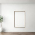 Minimalist interior with blank picture frame on white wall and potted plant on wooden floor Royalty Free Stock Photo