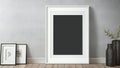Minimalist interior with blank picture frames leaning against a wall and a vase with branches, copy space available Royalty Free Stock Photo