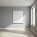 Minimalist interior with a large, empty white frame on a gray wall. Natural light streams through a Royalty Free Stock Photo
