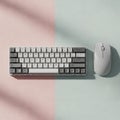 Compact mechanical keyboard and wireless mouse on a light pink textured Royalty Free Stock Photo