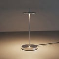 Minimalist lamp with a sleek, metallic design. It features a thin vertical rod supporting a flat, Royalty Free Stock Photo