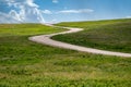 Minimalist landscape photo of prairie grassland in Custer State Park with blue sky clouds, as the road winds through