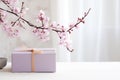 Minimalist lilac gift packaging and branches of cherry flowers in the interior Royalty Free Stock Photo