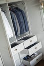 Minimalist male wardrobe neatly folded and hanging clothes dresser drawer vertical storage organizer Royalty Free Stock Photo