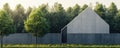 Minimalist modern architecture with concrete building surrounded by lush green forest and grass Royalty Free Stock Photo