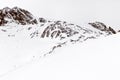 Minimalist mountain landscape. Ski trail and rock in the snow
