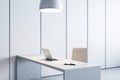 Minimalist office workspace with laptop, chair, and hanging lamp. Modern design.
